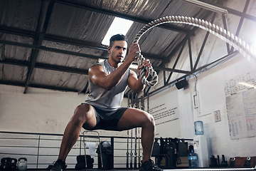 Image showing Health, gym and battle rope workout with man at a fitness center, cardio and muscle training. Power, energy and exercise by muscular athlete focused on intense movement, strength and endurance