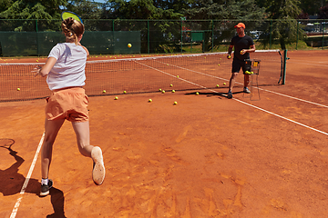 Image showing A professional tennis player and her coach training on a sunny day at the tennis court. Training and preparation of a professional tennis player