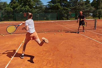 Image showing A professional tennis player and her coach training on a sunny day at the tennis court. Training and preparation of a professional tennis player