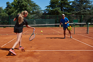 Image showing A professional tennis player and her coach training on a sunny day at the tennis court. Training and preparation of a professional tennis player