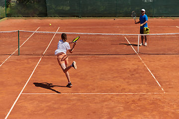 Image showing A professional tennis player and her coach training on a sunny day at the tennis court. Training and preparation of a professional tennis player