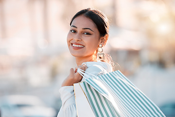 Image showing Woman, retail shopping bag and city travel for discount sales, market and fashion promotion in urban Dubai UAE. Portrait of happy, rich wealth and smile young arab girl customer buying luxury outdoor