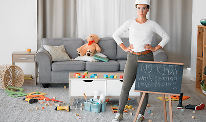 Image showing Cleaning, living room and blackboard with a woman mother in her home to clean up children toys off of the floor. Mom, cleaner and mess with a strict female in messy lounge with a helmet and goggles