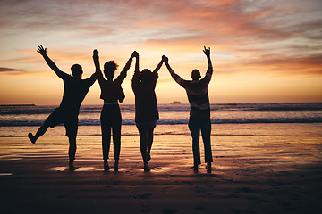 Image showing Silhouette, sunset and friends holding hands at the beach on holiday in Miami during summer. Group of people with support, community and calm on a vacation by the water and sea for peace in nature