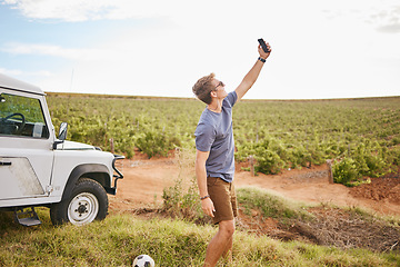 Image showing Phone selfie, travel and car road trip nature of a man using a mobile outdoor on a drive break. Countryside, summer vacation and person using technology near a agriculture farm and motor transport