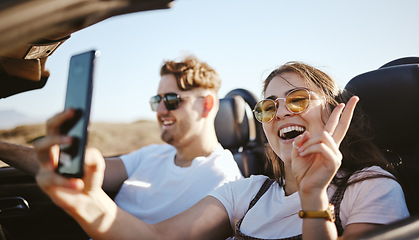 Image showing Couple, phone and travel for selfie in car for social media for summer vacation and laugh together. Happy man and woman on holiday road trip on mobile smartphone with a peace sign