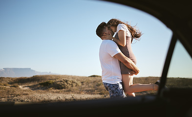 Image showing Kiss, love and couple on road trip with car in nature of California together during summer. Young man and woman kissing while on travel holiday with transport in the countryside for adventure