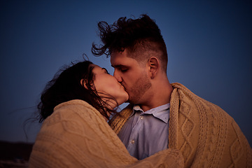 Image showing Kiss, love and winter with a couple at night in a blanket for romance, date or anniversary with a dark blue sky. Kissing, dating and honeymoon with a young man and woman sharing an intimate moment