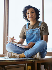 Image showing Artist, window and creative woman with sketch notebook sitting in classroom or artistic workshop. Happy college student, sketching and practice designer art portfolio skills in art studio