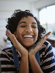 Image showing Woman artist, smile, happy and excited in her work studio, her hand with paint. Young painter, art and playful while working in workshop, painting and creative with watercolor during a break.