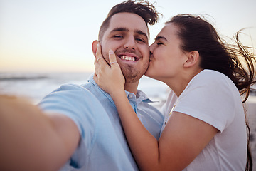 Image showing Selfie, beach and couple with kiss during holiday for love at beach in Australia after marriage in summer. Portrait of man and woman live streaming on social media with affection at sea for vacation