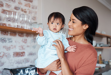 Image showing Love, happy mom and baby with down syndrome in kitchen in family home. Care, growth and support for child development for woman from India. Indian mother in house with cute toddler with disability.