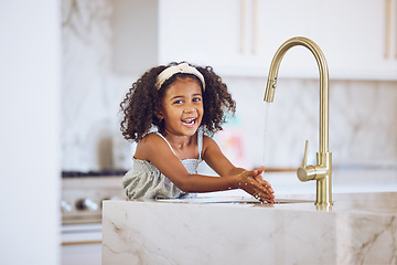 Image showing Clean, smile and African child washing hands with water by the tap in the kitchen in a house. Happy portrait of a girl kid cleaning her hand with liquid for health and safety from virus in her home