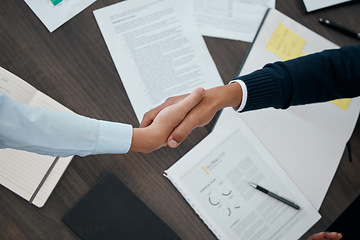 Image showing Business, hands and handshake with documents above paperwork for employment agreement or analysis at the office. Hand of people in partnership shaking for corporate contract, welcome or b2b meeting
