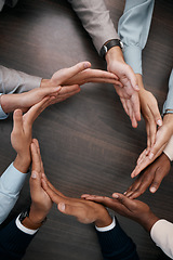 Image showing Hands, teamwork and synergy with business people in a circle or huddle as a team on a wooden table in the office. Collaboration, motivation and goal with an employee group working together on success