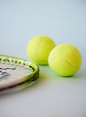 Image showing Sport, tennis ball and racket in an empty studio on a gray background for sports, fitness and exercise. Training, workout and health with still life equipment on the floor ready for a game or match