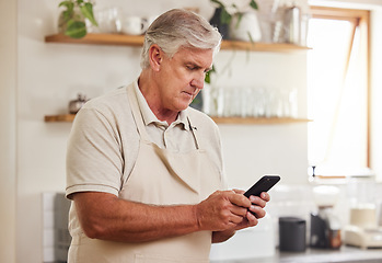 Image showing Typing, phone and senior man reading an email on a mobile app during retirement in his house. Elderly person with calm and peace while on the internet with a smartphone in the kitchen of his home