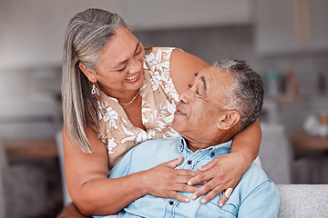 Image showing Hug, love and senior couple with smile for funny story while in the living room of their house. Happy, comic and elderly man and woman relax and hugging for support in the lounge of their home