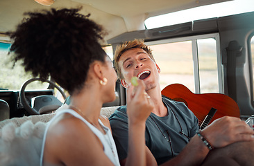 Image showing Couple eating on road trip, people travel in car with friends and vacation in Canada together. Black woman giving grape to boyfriend, funny man with open mouth and interracial love in camper drive