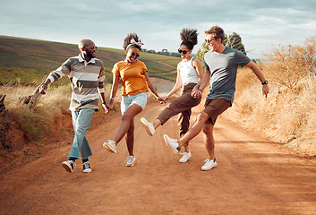 Image showing Travel, friends holding hands and dance in nature, outdoors or countryside on vacation. Happy, diversity and group smile, spending time together and dancing, celebration and having fun on sandy road.