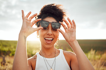 Image showing Black woman smile, wink and happy on summer countryside nature holiday at sunset. Girl with fashion sunglasses, laugh with happiness and peace on relax travel vacation trip at South Africa wine farm