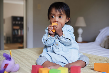 Image showing Down syndrome, baby and with colorful toys, happy or being playful in bedroom at home. Child development, disability and kid or toddler playing with building blocks relax, daycare learning and on bed