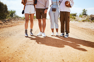 Image showing Shoes, shadow and friends on a sand road in the desert for summer holiday or vacation while walking together in nature. Travel, legs and adventure with a man and woman group standing on a footpath