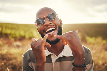 Image showing Hand sign, freedom and summer with a black man enjoying nature outdoor alone during the day. Shaka, happy and carefree with a young male outside posing outside with a cheerful expression of fun