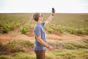 Image showing Nature, phone and a man with lost signal in field on farm road trip. Travel, view and vineyard, young traveler with smartphone in agriculture. Gps, wifi or 5g network search on mobile in grass field.