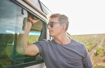 Image showing Travel, adventure and man by his car in the countryside while on a roadtrip during summer vacation. Sunshine, outdoors and young person in nature, relax on journey and traveling lifestyle.