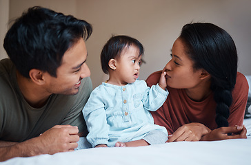 Image showing Family, parents and Down syndrome baby with love, care for relaxing and spending quality time together at home. Mother and father relax on bed playing with new born child with genetic disorder