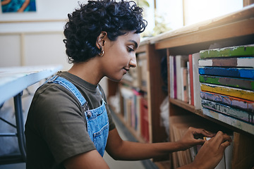 Image showing Books, creative and Indian student search bookshelf for reading poetry information, learning or knowledge in a work studio or classroom. Teenager woman with history, philosophy or dictionary research