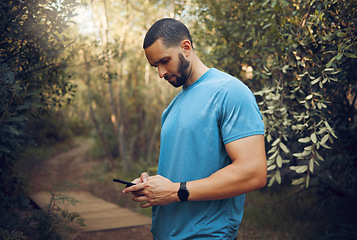 Image showing Sports man, phone and runner in a forest taking a break while texting, communication and typing a message while out for a run. Male athlete out for workout in woods using technology to track health