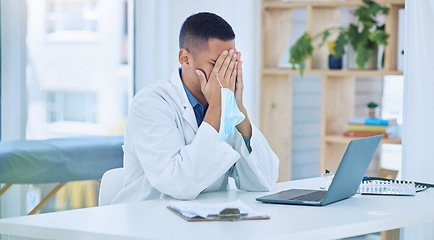 Image showing Covid doctor, tired in office from stress and face mask in hand after writing report on laptop with patient information documents. Coronavirus, medical professional burnout and exhausted from covid19