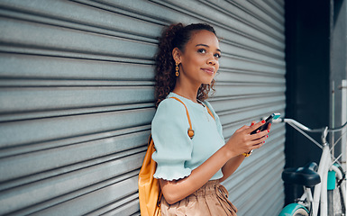 Image showing City lifestyle, girl with phone and bike standing at wall thinking before writing text. Happy female student, bicycle and smartphone outside street, communication, 5g and sustainable urban transport.