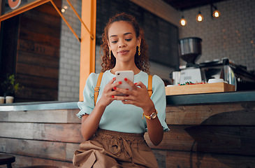 Image showing Phone, social media and coffee shop with a woman typing a text message while sitting in a cafe to relax. Internet, mobile and communication with a young female customer in a restaurant texting