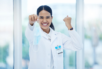 Image showing Doctor, happy and celebration with mask off face for end of covid 19, pandemic and coronavirus. Woman, medic and smile in hospital, clinic or healthcare cheering for stop of virus, bacteria or germs