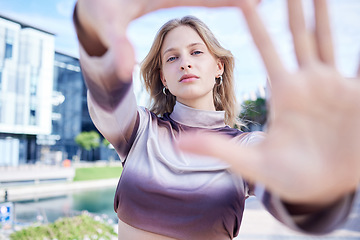 Image showing Fashion, hands and frame with the face of a woman with beauty outside in the city. Portrait, style and model with an attractive or edgy female standing outside on an urban background in summer