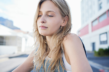 Image showing Thinking girl in the street in the city, sad expression on her face. Young student sitting in road in urban town with mindful thoughts, depression and mental health. Woman alone, sadness and stress