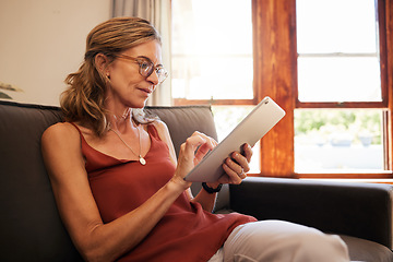 Image showing Relax, ecommerce and retirement woman on tablet with glasses reading on internet at home in Canada. Senior person looking at online shopping deals on retail app while resting on living room sofa.