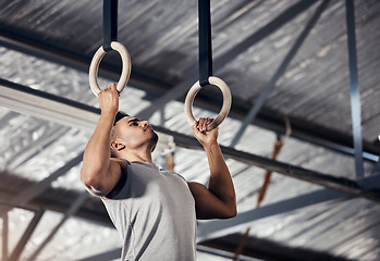 Image showing Fitness, exercise man in gymnastics gym during pull up, training or exercise on rings. Young sports athlete or gymnast, strong mindset and start workout to improve muscle or cardio at sport club