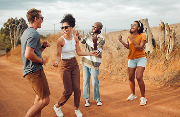 Image showing Friends, dance and nature with a man and woman group having fun outdoor during travel or adventure together. Summer, vacation and freedom with young people dancing on a sand road in the desert