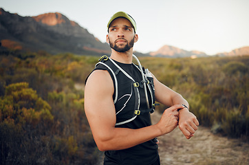 Image showing Fitness, man and smart watch time for mountain running, exercise workout or healthy hiking trail training. Focus runner monitor stopwatch, check steps and cardio progress for wellness goals in nature