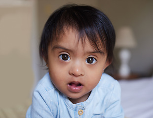 Image showing Face, down syndrome baby and bedroom portrait in home alone, looking innocent and cute. Disability, childhood development and toddler, Indian kid or newborn girl relaxing on bed, curious and adorable