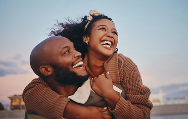 Image showing Happy black couple, love and hug laughing in joyful happiness for bonding time together in the outdoors. African American man and woman enjoying playful fun piggyback with smile for holiday in nature