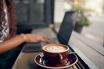 Image showing Coffee, laptop and business owner working, planning and typing on internet at a coffee shop. Remote worker with a cappuccino at a cafe or restaurant for wifi connection to work online with a computer