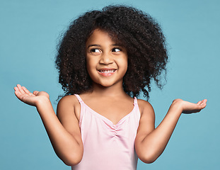 Image showing Girl, hands and smile with confused, question and guess against studio background. Kid, model and confusion do sign for doubt against blue backdrop with shrug, afro and natural hair on surprise child