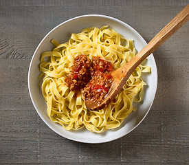 Image showing bologna sauce is added to a bowl of pasta