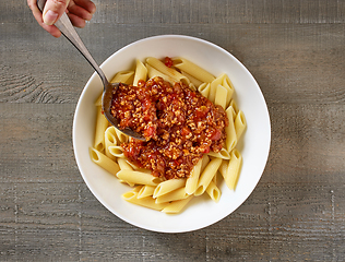 Image showing bologna sauce is added to a bowl of pasta