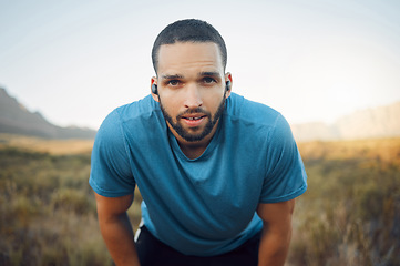 Image showing Portrait of tired runner, music for motivation on earphones and man taking a break from a nature fitness run. Running for exercise, cardio health workout and enjoy freedom of sport training in nature